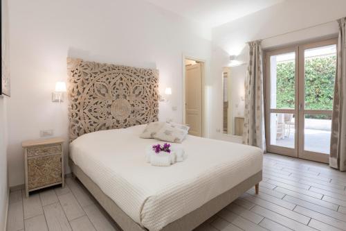 a bedroom with a white bed with flowers on it at Sardinia Lighthouse Apartment in Palau