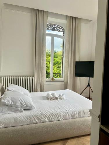 a bedroom with a bed with a window at Suite Arche - Maison les Arcades au pied de la Gare de Charleville-Mézières in Charleville-Mézières