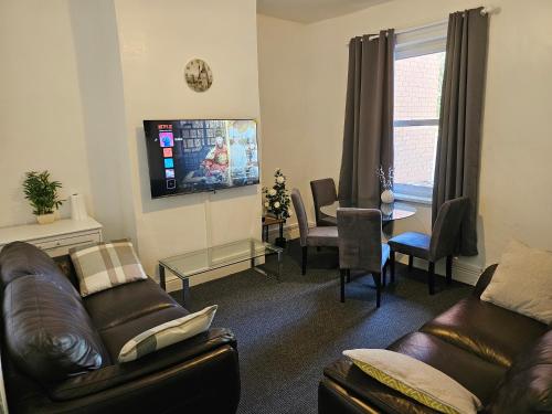 a living room with two couches and a tv at Convenient 3 bed, Pr1 near Uclan n Train station in Preston