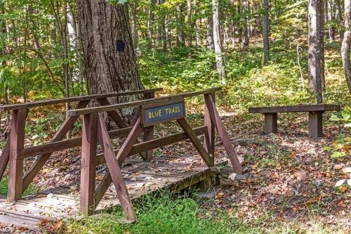 a sign on a wooden bridge in the woods at Wooded Nest, Cozy 3BR Chalet Near Spas, Downtown Berkeley Springs & Hiking in Berkeley Springs