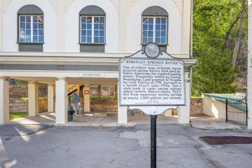 a sign in front of a white building at Wooded Nest, Cozy 3BR Chalet Near Spas, Downtown Berkeley Springs & Hiking in Berkeley Springs