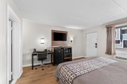 a bedroom with a bed and a desk with a computer at Econo Lodge Cranston - Providence in Cranston
