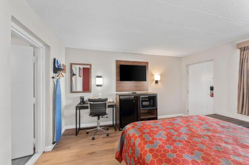 a hotel room with a bed and a desk at Econo Lodge Cranston - Providence in Cranston