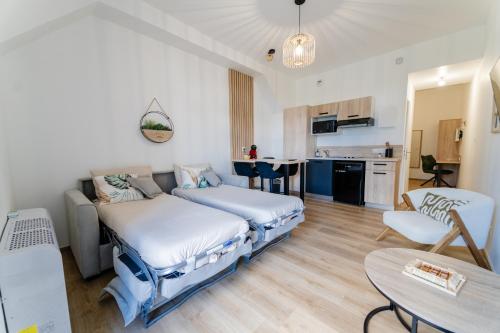 a living room with two beds and a kitchen at Domaine du Vieux Porche in Mignaloux-Beauvoir