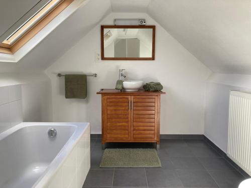 a bathroom with a tub and a sink and a mirror at Logies Villa Zilt in Koksijde