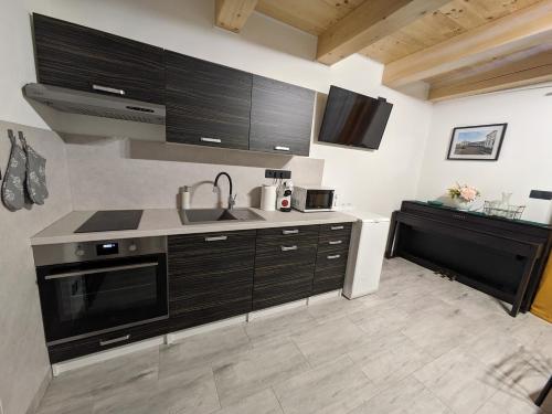 a kitchen with black cabinets and a sink and a counter at Apartmány U Lazara in Kutná Hora