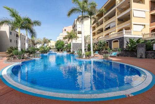 a large blue swimming pool in front of a building at Bright Retreat with Lush Outdoor Space in Palm-Mar