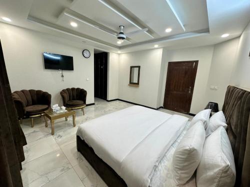 a bedroom with a bed and a couch and a chair at Comfort Family Lodges in Islamabad