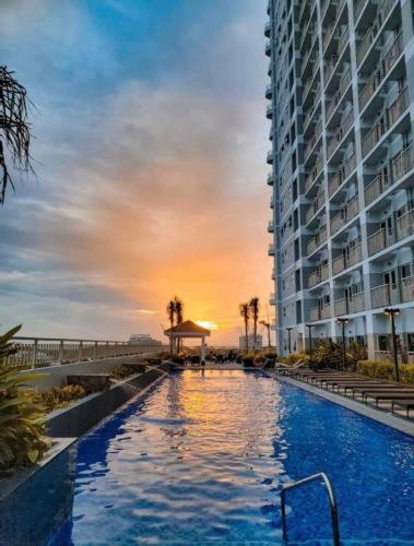 a large swimming pool next to a tall building at Penthouse Lvl Luxury Cndo Nr MOA in Manila