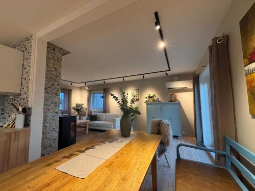 トロムソにあるCentral and rural house with beautiful viewのリビングルーム付きの客室で、大きな木製テーブルが備わります。