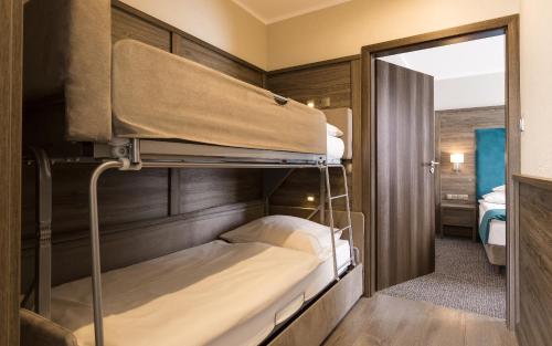 a room with two bunk beds and a mirror at Hotel Konradówka Wellness & SPA - 300 metrów do centrum in Karpacz