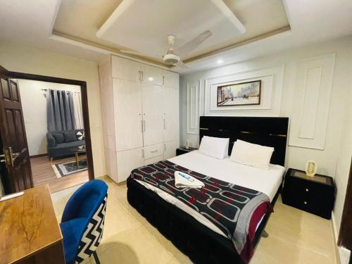 a bedroom with a bed and a table and a chair at Modern 2BHK Islamabad in Islamabad