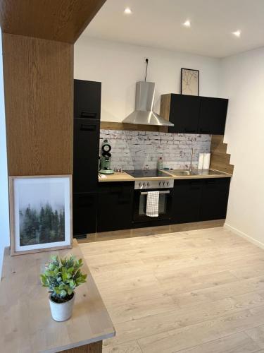 a kitchen with black cabinets and a table with a picture at Kurpark Ferienwohnung in Schleiden