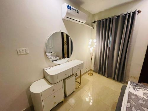 a bathroom with a white sink and a mirror at Modern 2BHK Islamabad in Islamabad