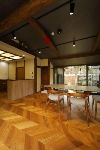 a room with wooden floors and tables and chairs at Basara Kinmokusei 金木犀Kyoto Machiya in Kyoto