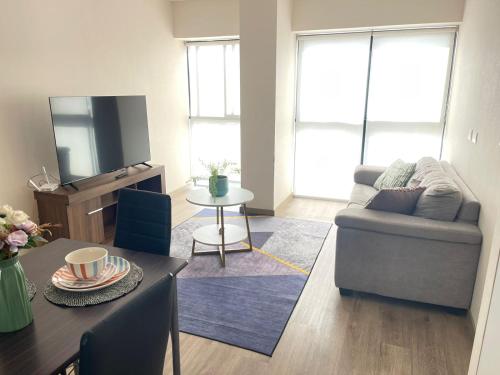 a living room with a couch and a table at Departamento Frente al CC el Polo in Lima