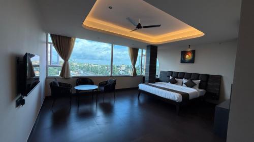 a bedroom with a bed and a large window at Hotel Pixel House in Hubli