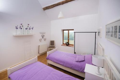 two beds in a room with purple sheets at Villa Souvenir, Lenax in Lenax