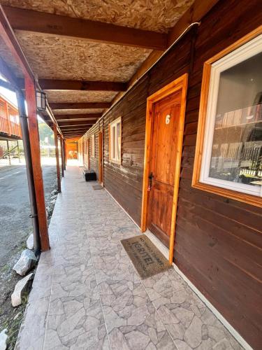 Un pasillo vacío de un edificio de madera con una puerta. en Habitaciones triples PIA, en Puerto Tranquilo