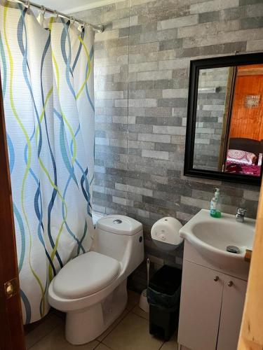 un baño con inodoro y lavabo en Habitaciones triples PIA, en Puerto Tranquilo
