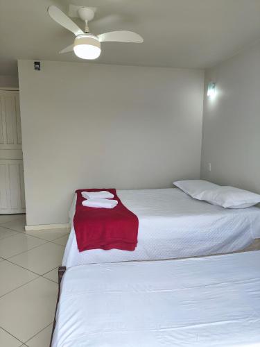 a bedroom with a bed with a red blanket on it at Hotel Estação in Diamantina