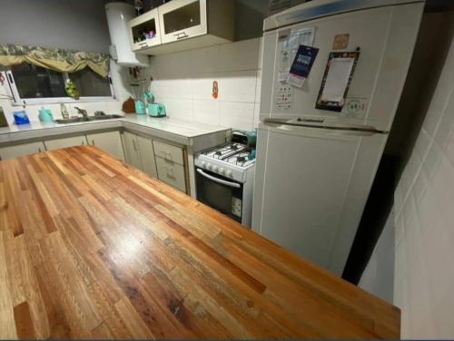 Una cocina con suelo de madera y nevera. en VIVA clara, en Santa Clara del Mar