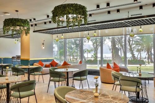 a restaurant with tables and chairs and large windows at Rixos Montaza Alexandria in Alexandria