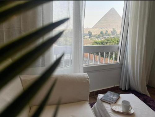 Habitación con ventana con vistas a las pirámides. en Desert Glow Pyramids INN, en El Cairo
