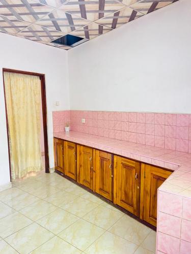 a pink kitchen with wooden cabinets and a pink counter top at River Park Holiday Home in Badulla