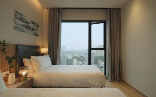 a bedroom with two beds and a large window at Honey Wink - Zenity & D1 - Apartment in District 1 in Kon Rung (1)
