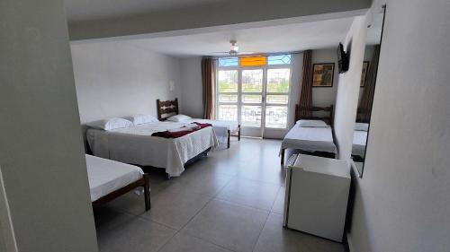 a hotel room with two beds and a window at Hotel Estação in Diamantina