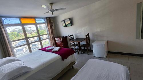 a bedroom with two beds and a window at Hotel Estação in Diamantina