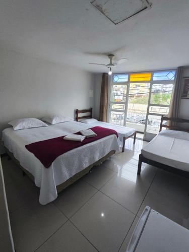 a bedroom with a large bed and a window at Hotel Estação in Diamantina