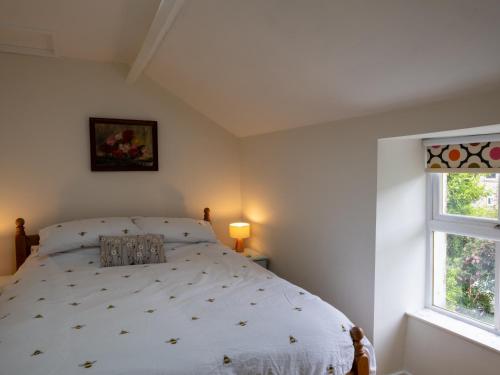 a bedroom with a bed and two windows at Snowdonia Eryri Cottage, Moel Siabod in Dolwyddelan