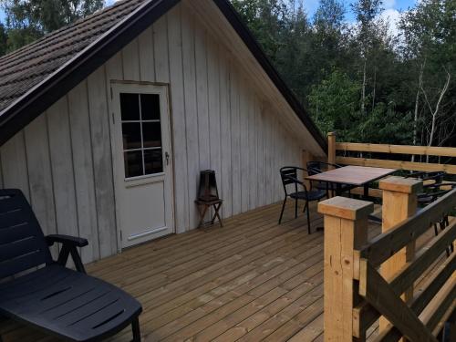 a wooden deck with a table and chairs on it at House in nature in Broby