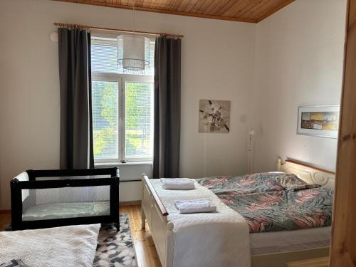 una camera da letto con due letti e una finestra di Liepeen pappila a Pudasjärvi