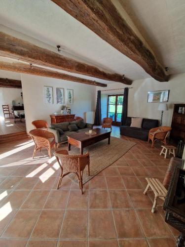 ein Wohnzimmer mit einer Couch und einem Tisch und Stühlen in der Unterkunft Paimpont: Gîte de la Haute Fenderie in Paimpont