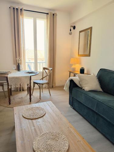 a living room with a green couch and a table at Studio Saint-Rémy-de-Provence centre in Saint-Rémy-de-Provence