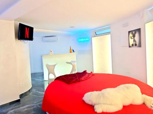 a bedroom with a red bed with a red blanket at The Igloo Milano -Luxury Eclectic Suite - Jacuzzi - MilanoFlats in Milan