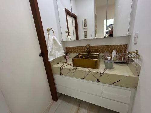 a bathroom with a sink and a mirror at Raridade Cachoeiro, Apto 2 Qtos, Ar, Ferroviários in Cachoeiro de Itapemirim