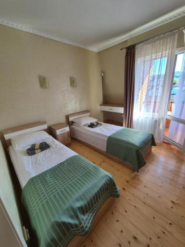 two beds in a room with a window at Садиба Святослав in Skhidnitsa