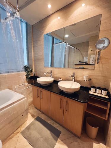 une salle de bain avec deux lavabos et un grand miroir dans l'établissement Dubai Marina Modern 1 Bedroom Apartment steps to tram & Marina Walk, à Dubaï