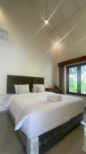 a large white bed in a room with a window at Tegala Home in Payangan