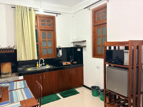 a kitchen with a sink and a microwave at Metro Stay in Kurunegala