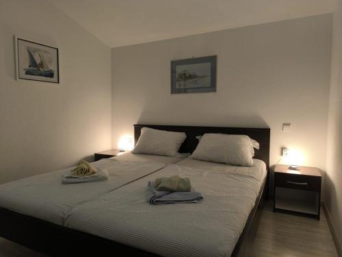 um quarto com uma cama grande com duas lâmpadas em cima em Apartments Hrvoje em Primošten