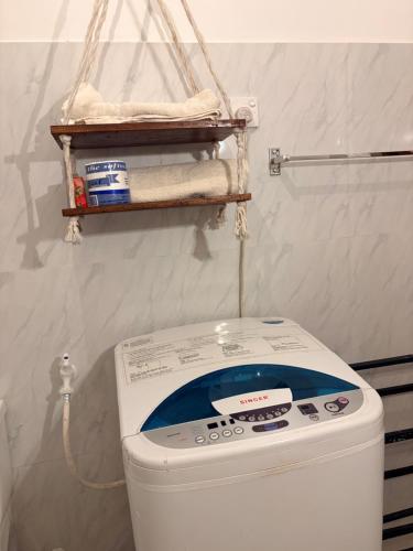 a toilet in a bathroom with a towel rack above it at Metro Stay in Kurunegala