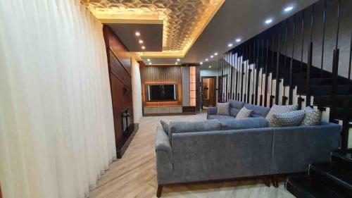 a living room with a couch and a television at Kinda vip in Al Mashāriqah