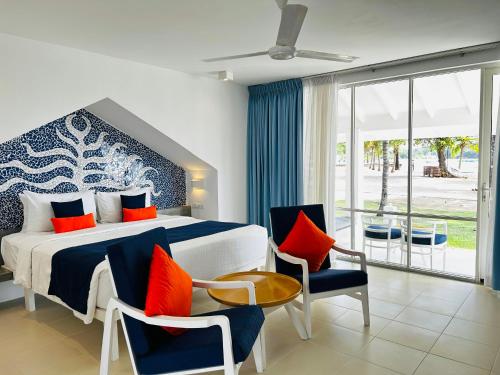 a bedroom with a bed with blue and orange pillows at Trinco Blu by Cinnamon in Trincomalee