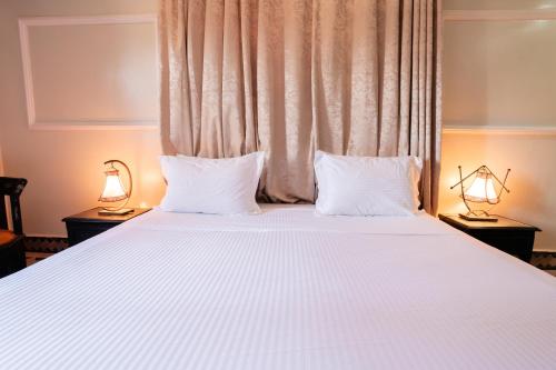 a bedroom with a large bed with two white pillows at Villa Marrakchia - Palais d'hôtes & spa in Marrakech