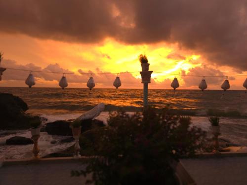 a sunset on the beach with a group of boats at Respect Homestay Phu Quoc in Phu Quoc